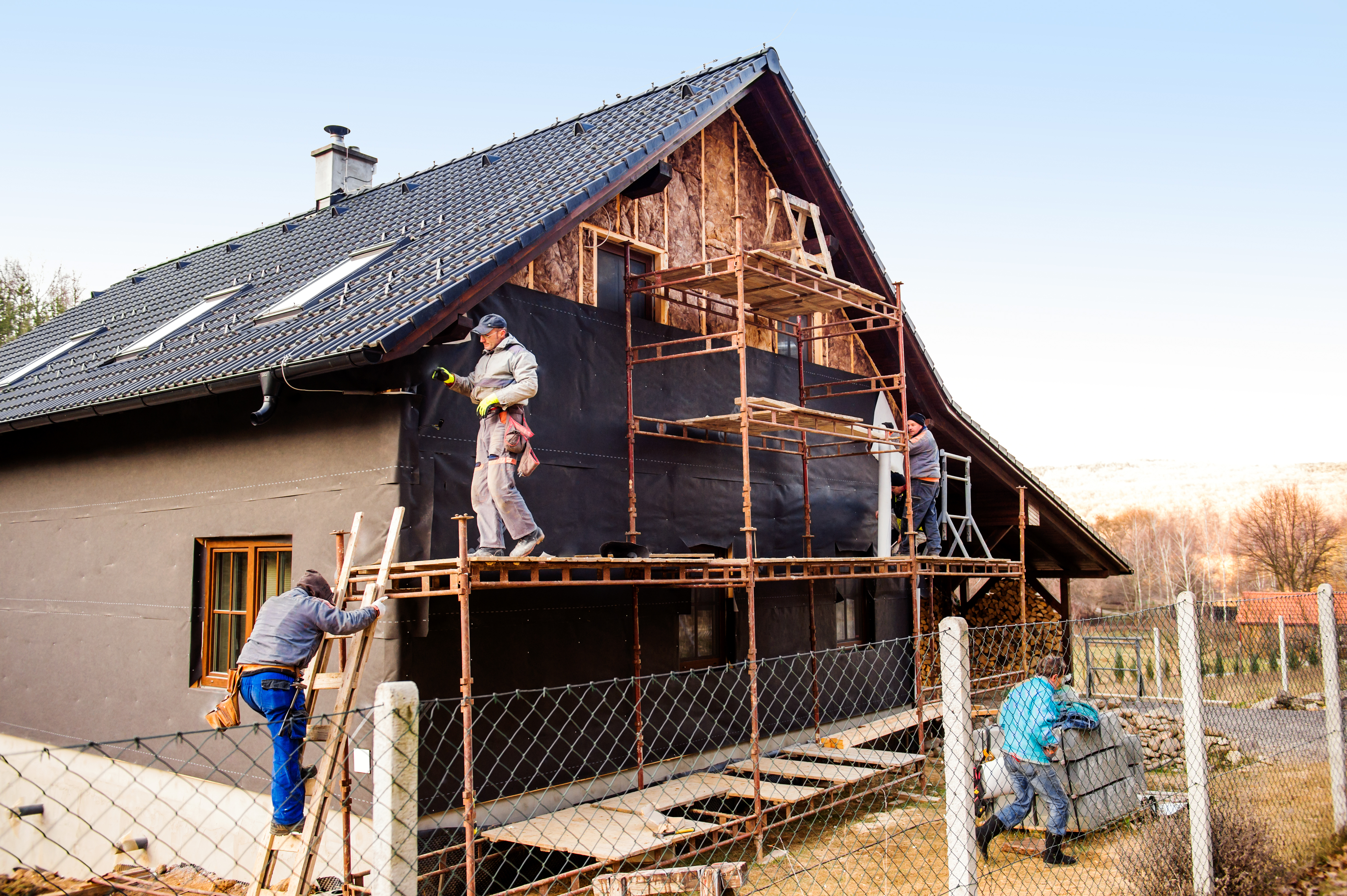 construction-workers-standing-on-scaffold-thermally-insulating-house