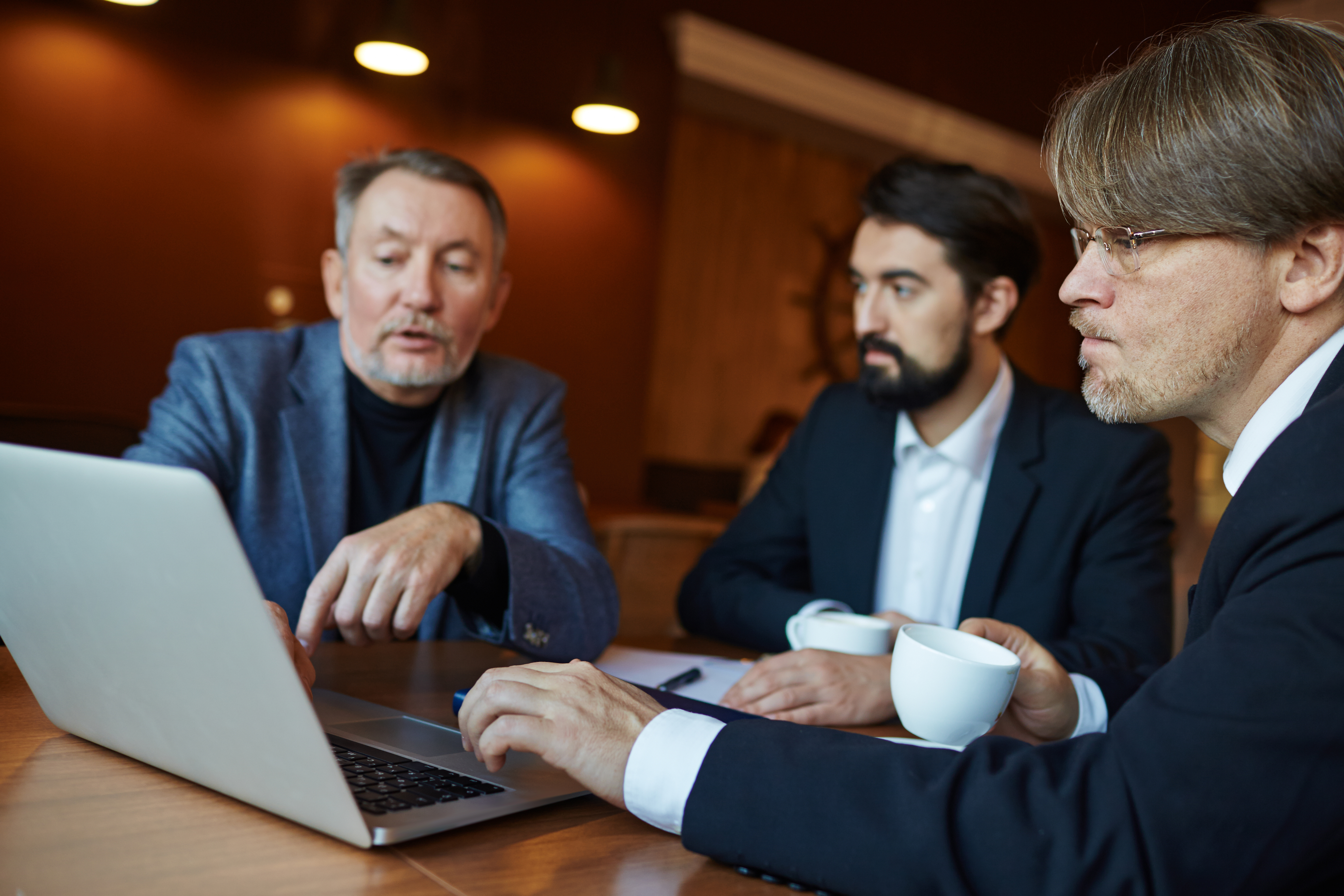 profile-view-of-concentrated-middle-aged-businessman-in-eyeglasses-holding-cup-of-coff